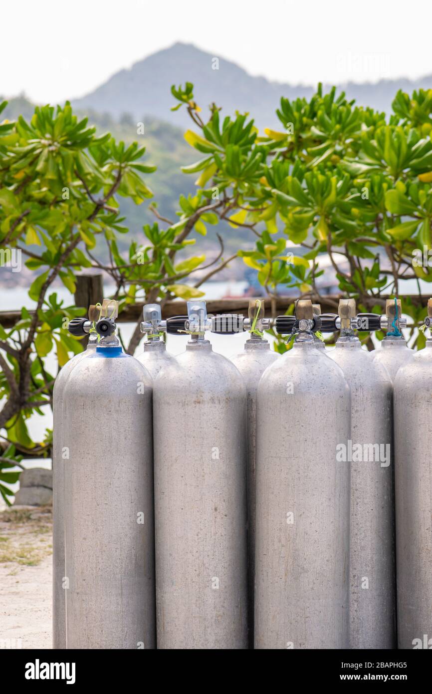 A lot of aluminum scuba diving oxygen tanks standing in front of the