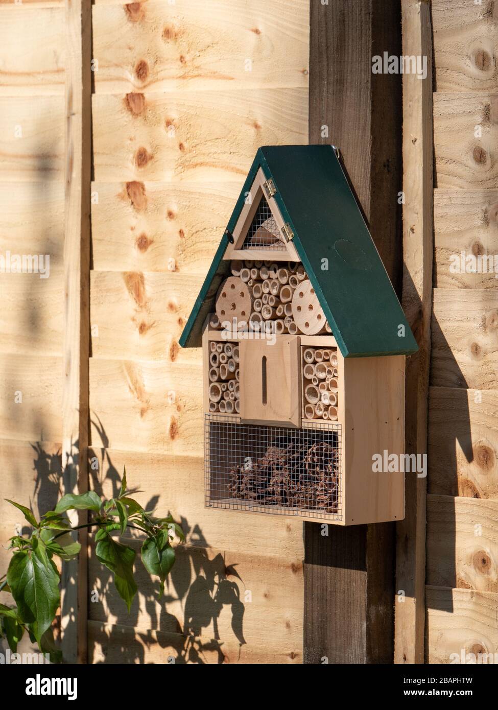 A new Bug Hotel in-situ on garden fence post. Stock Photo