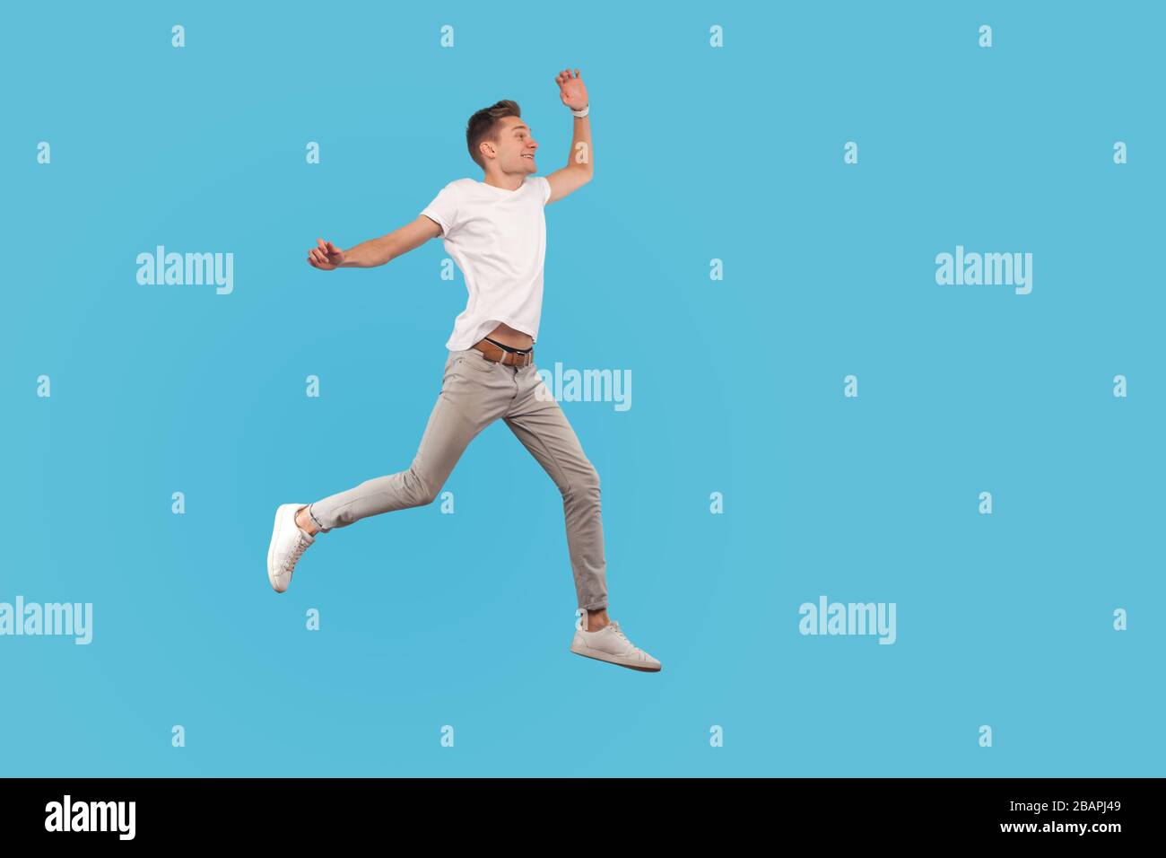Full length, excited man in casual outfit running quickly, hurrying to his dream, walking in air with enthusiastic face, believing in success and luck Stock Photo