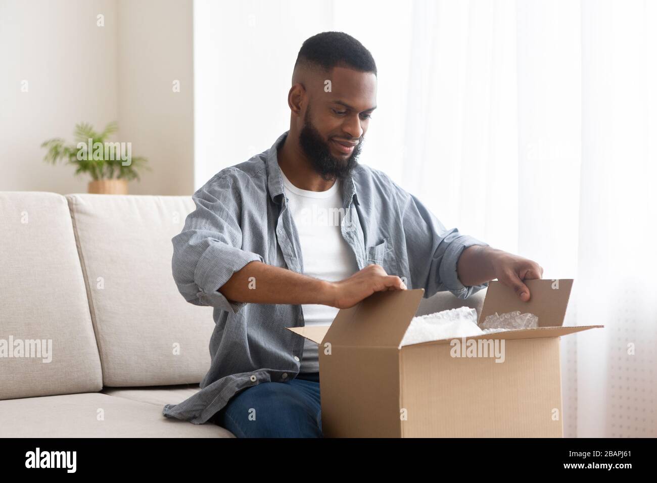 Male buyer unpack cardboard box at home Stock Photo