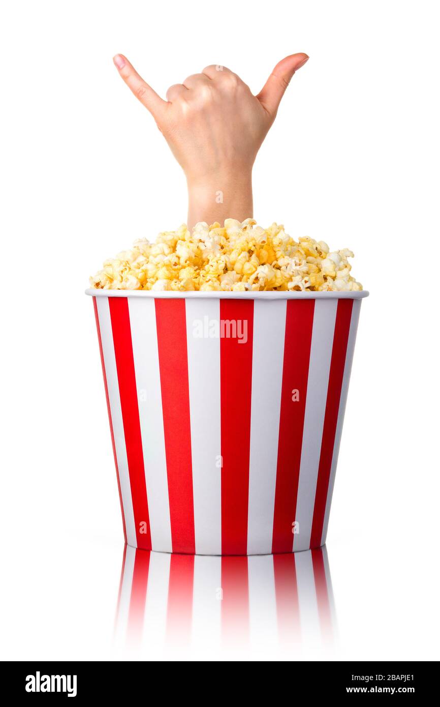Female hand sticks out of a bucket with popcorn showing Shaka or surfer sign isolated on white background. Isolated with clipping path. Stock Photo