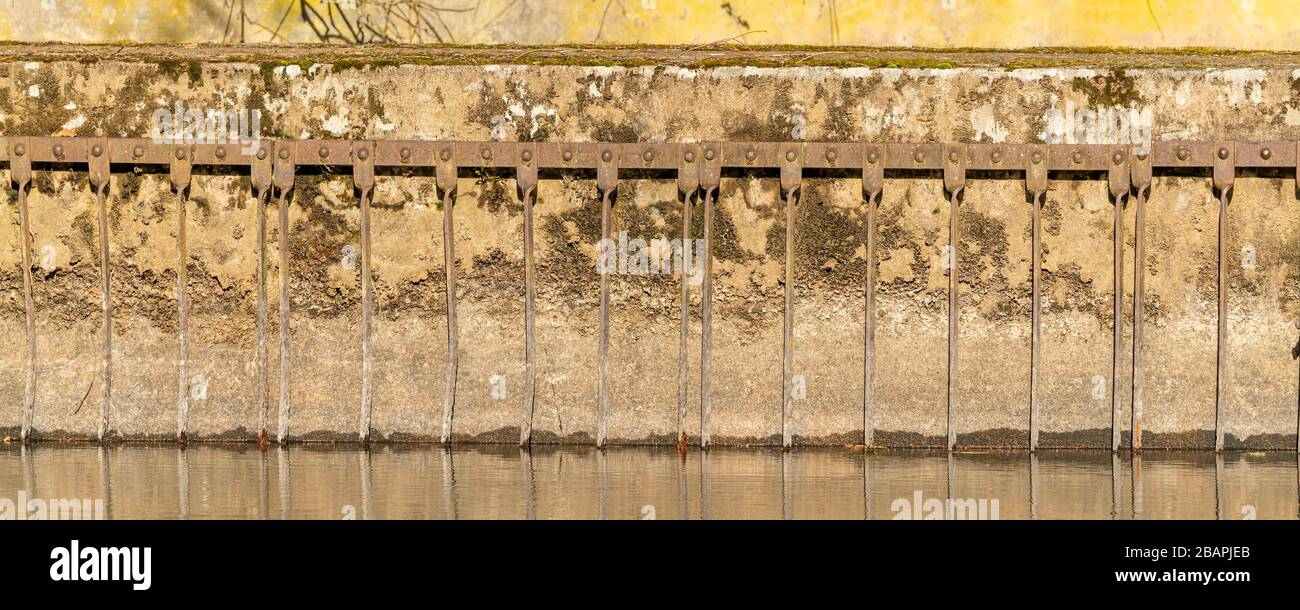 old wall and iron bars at the water, texture Stock Photo