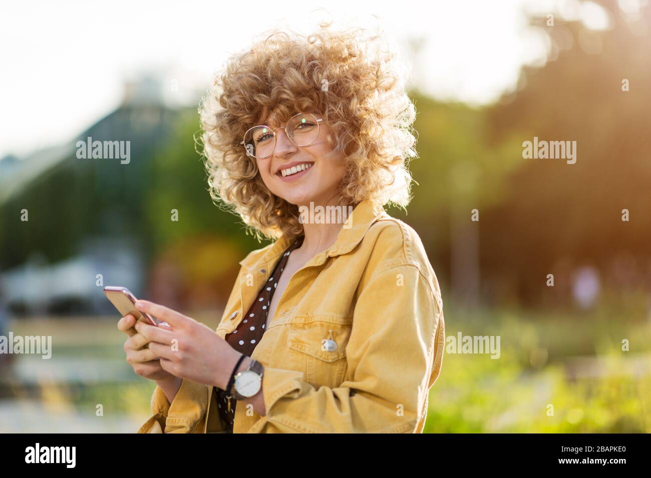 Portrait of young woman with curly hair Stock Photo - Alamy