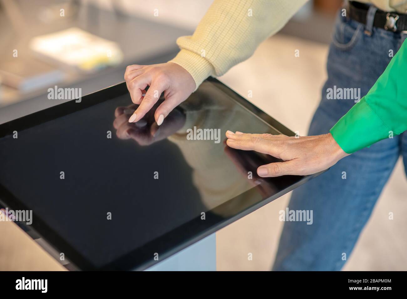 Device, gadget. Female hands touching thin beautiful fingers on the screen of the device for searching. Stock Photo