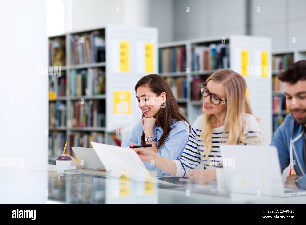 University students working in the library at campus Stock Photo