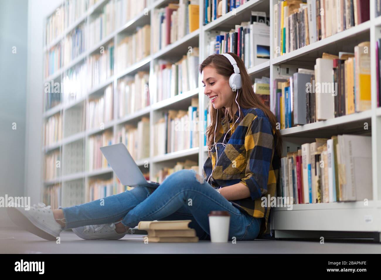 Young female student studying in the library Stock Photo
