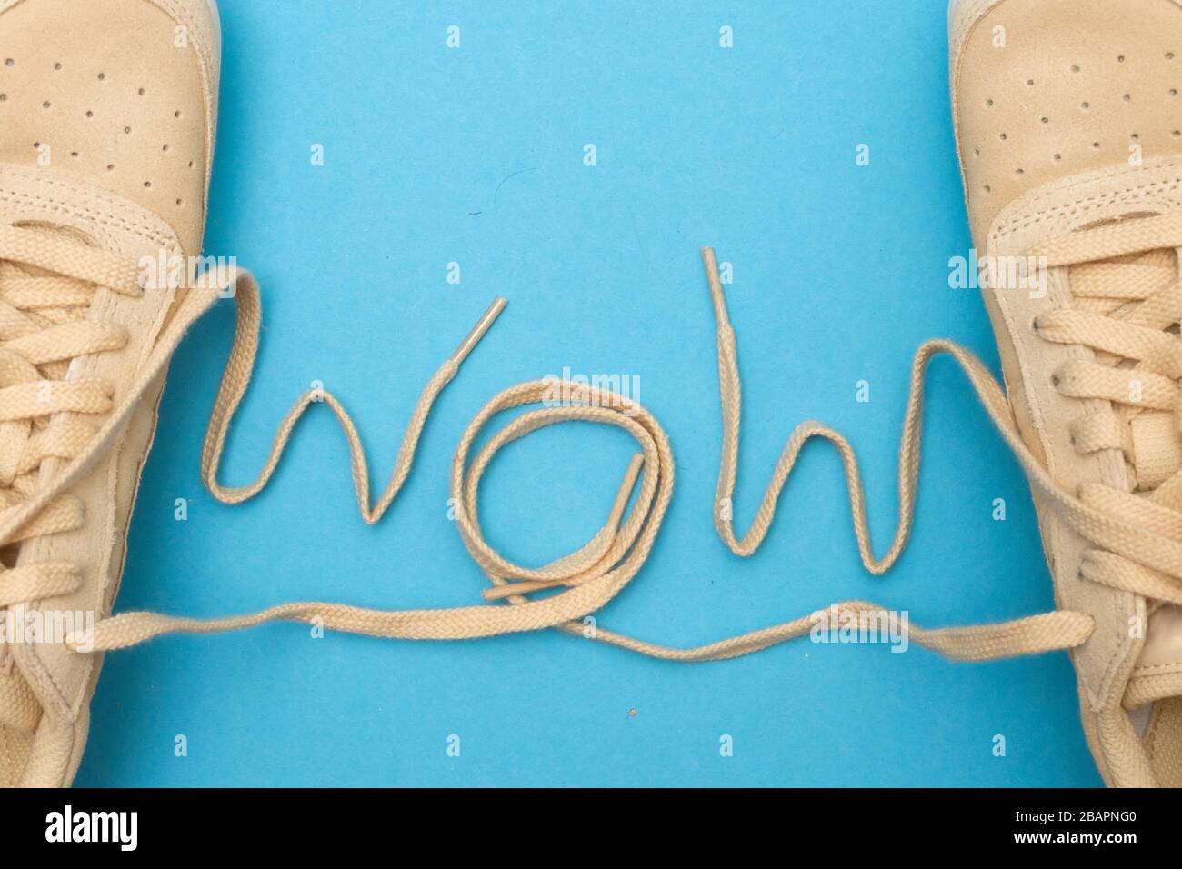 The word Wow made from laces of shoes on blue wall Stock Photo - Alamy