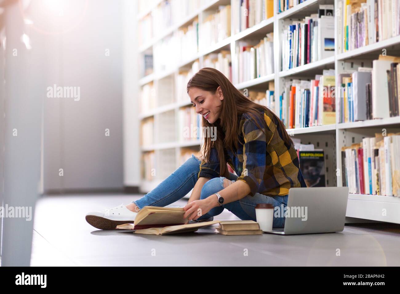 Young female student studying in the library Stock Photo