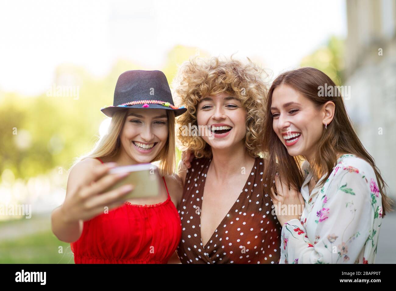 Three happy young women having fun with smart phone Stock Photo - Alamy