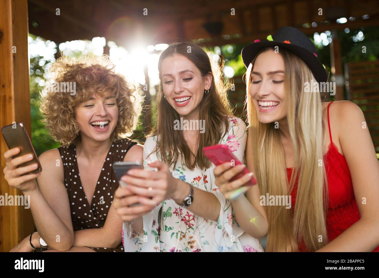 Three happy young women having fun with smart phone Stock Photo - Alamy