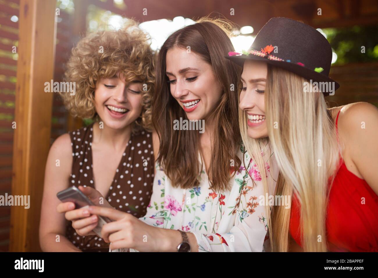Three happy young women having fun with smart phone Stock Photo