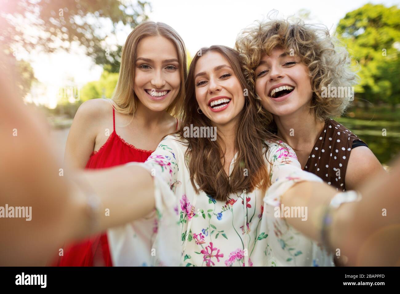 Three happy young women having fun with smart phone Stock Photo - Alamy