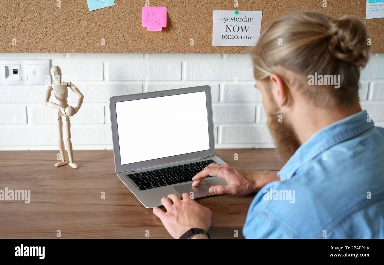 Young man using laptop e learning browsing internet with mock up blank screen. Stock Photo