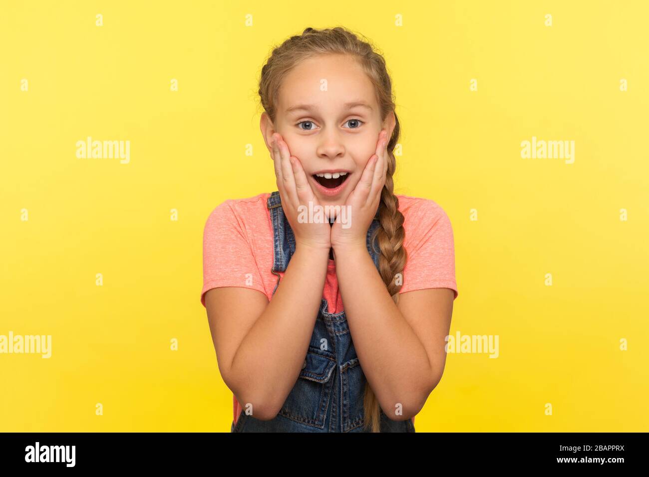 Awesome unexpected event. Portrait of astonished little girl touching face in surprise, expressing amazement, child shocked by sudden crazy news. indo Stock Photo