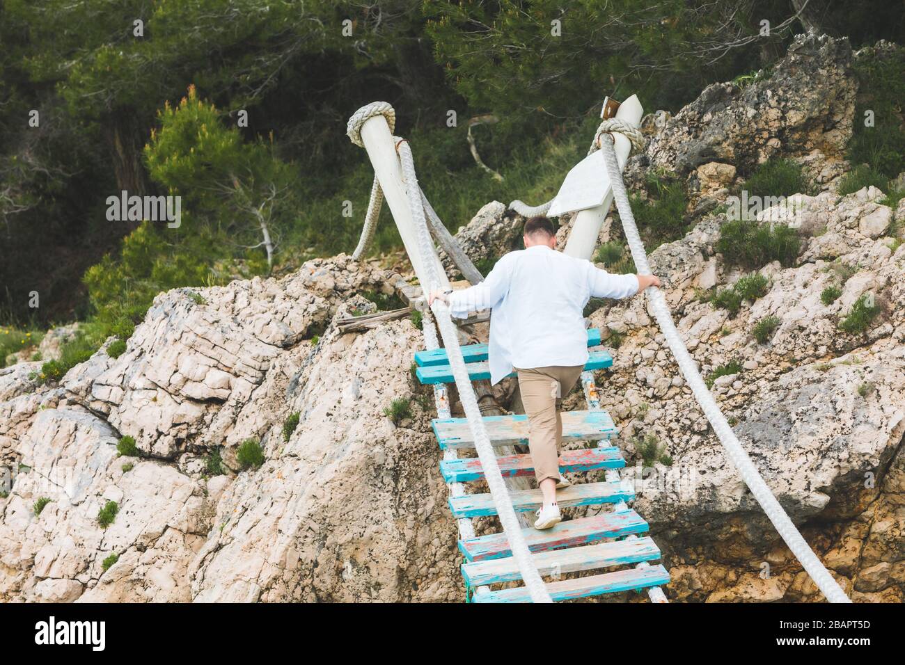 man walking by suspension bridge cross sea Stock Photo - Alamy
