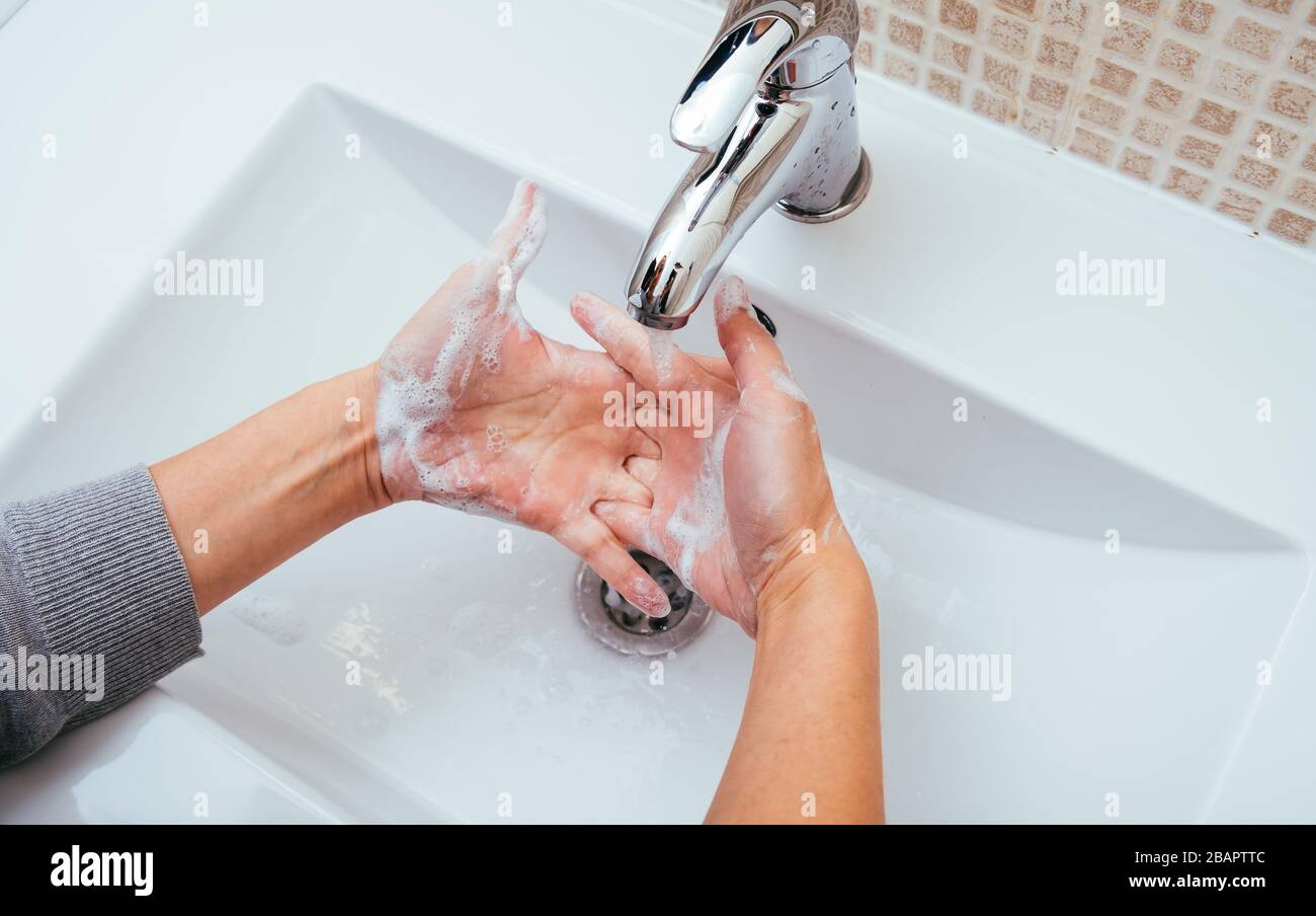 Woman Washing her hands with soap and water at home bathroom. Cleansing ...
