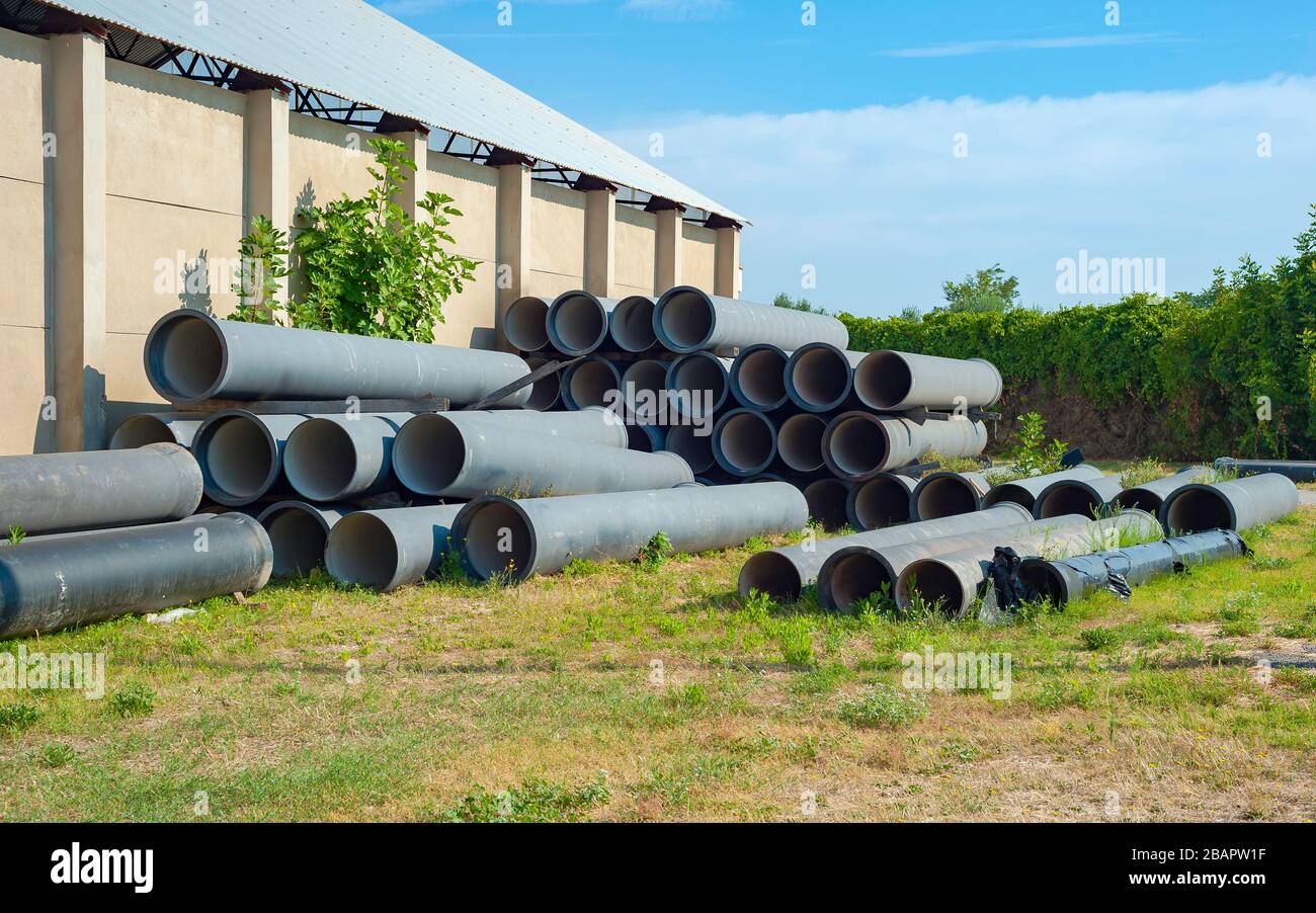 Fiberglass pipes bound with yellow rope at construction site. Also known as fiberglass conduit for electrical, industrial, and mechanical use. Stock Photo