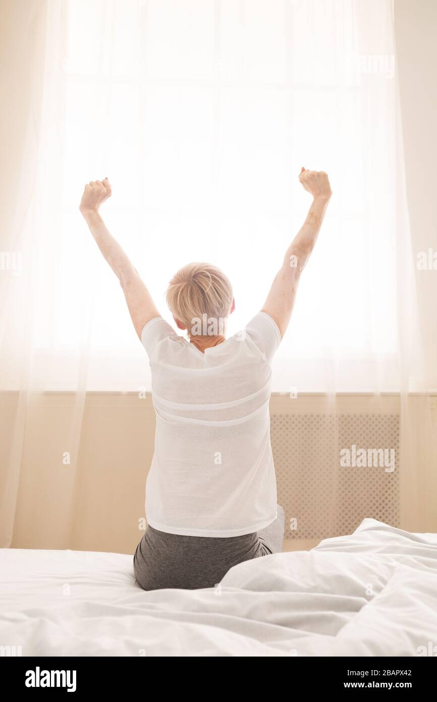 Woman stretching in cozy bed after good dreams Stock Photo
