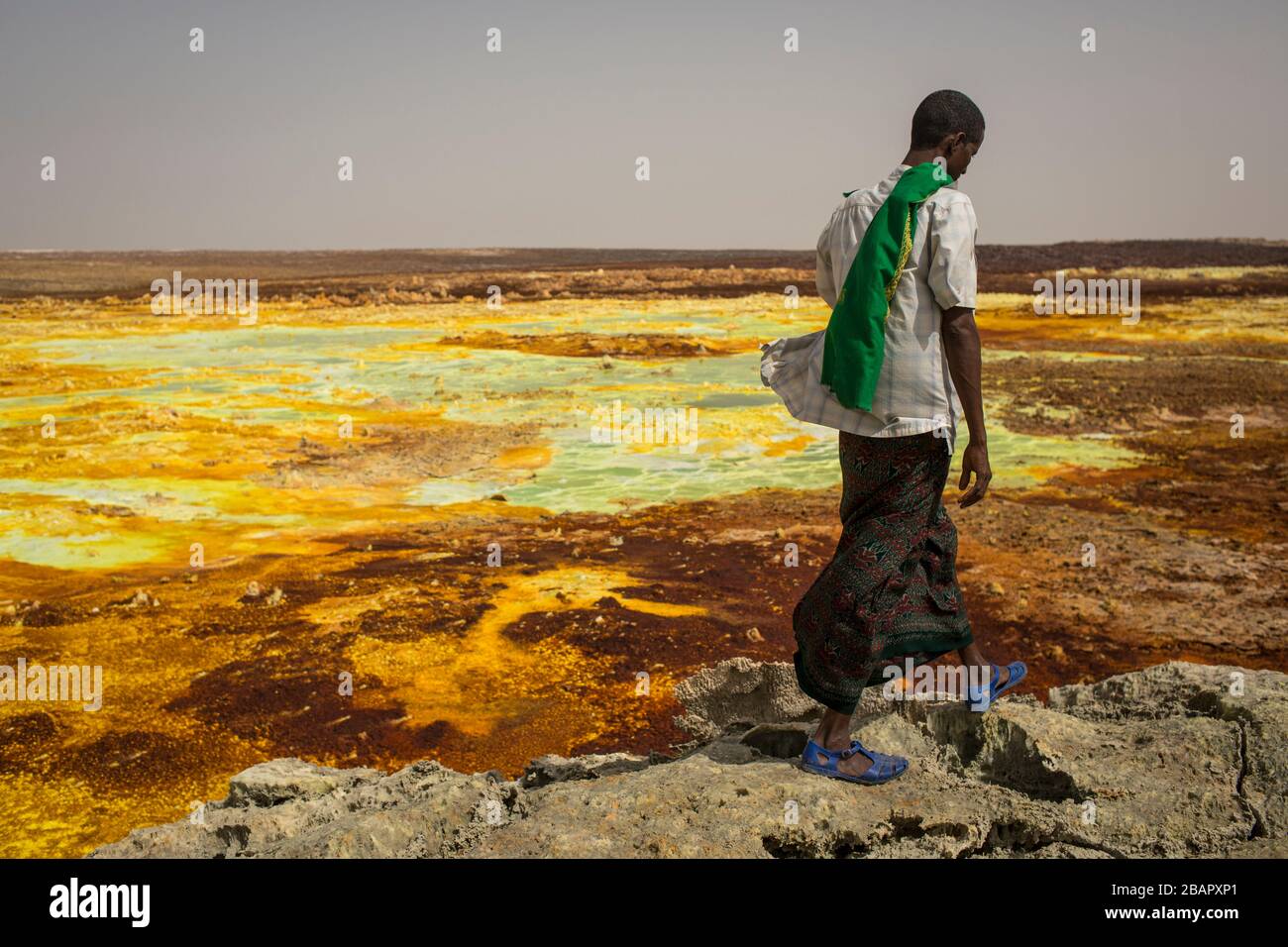 A man walks on sulphur and mineral salt formations near Dallol in the Danakil Depression, northern Ethiopia April 22, 2013. Stock Photo