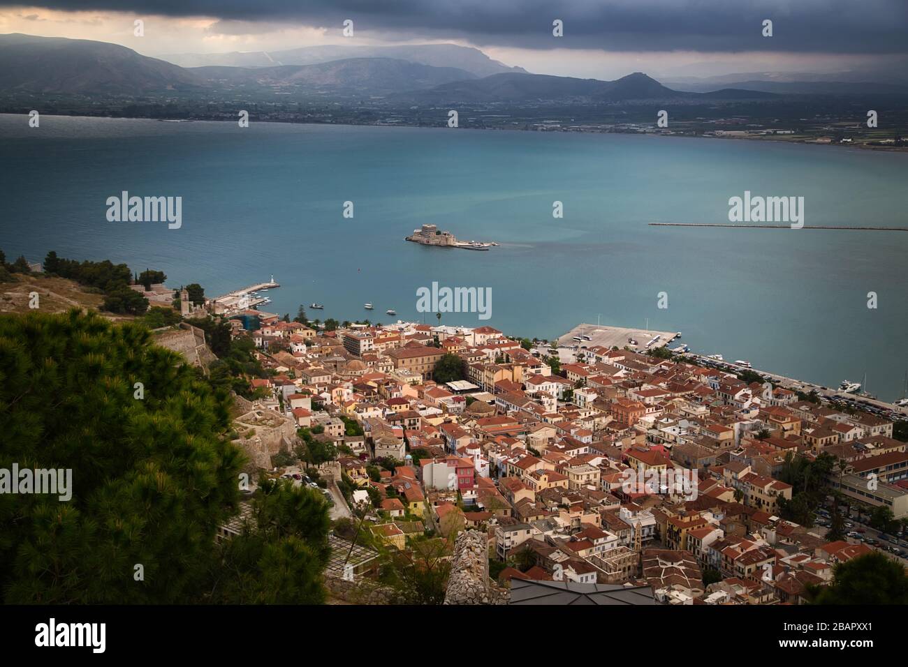 Old town of Nafplion in Greece, view from above with tiled roofs, small port and Bourtzi castle on the Mediterranean sea water Stock Photo