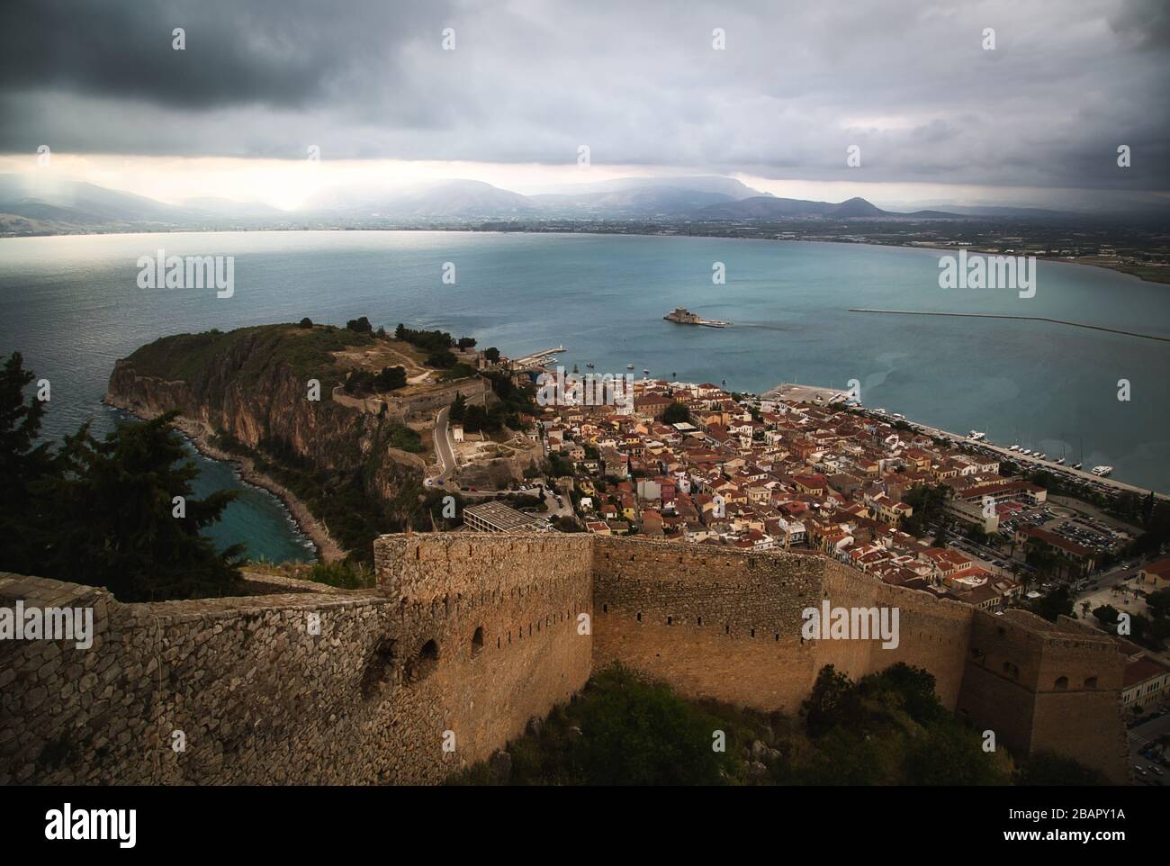 Old town of Nafplion in Greece, view from above with tiled roofs, small port and Bourtzi castle on the Mediterranean sea water Stock Photo
