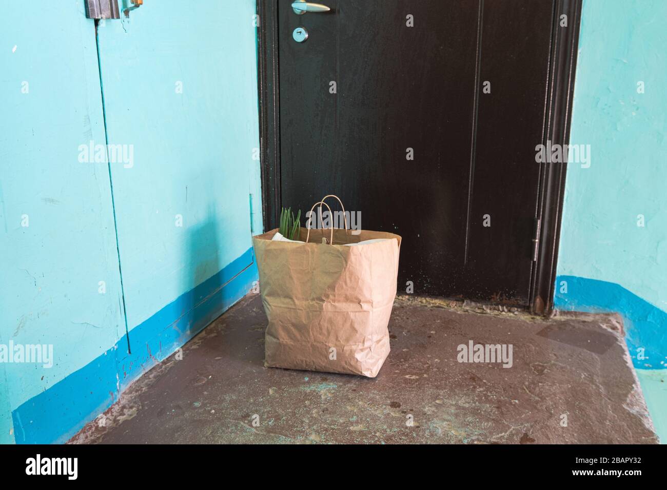Delivery during quarantine. Self-isolation. Social Services. A paper bag with goods and food in front of the door, the concept of neighborhood Quarant Stock Photo