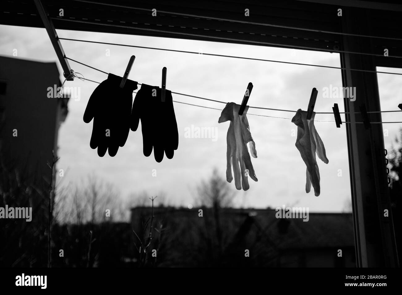 Kranj, Slovenia, March 21, 2020: Washable protective hand gloves hang out on the balcony to dry during the coronavirus outbreak nationwide lockdown. Stock Photo