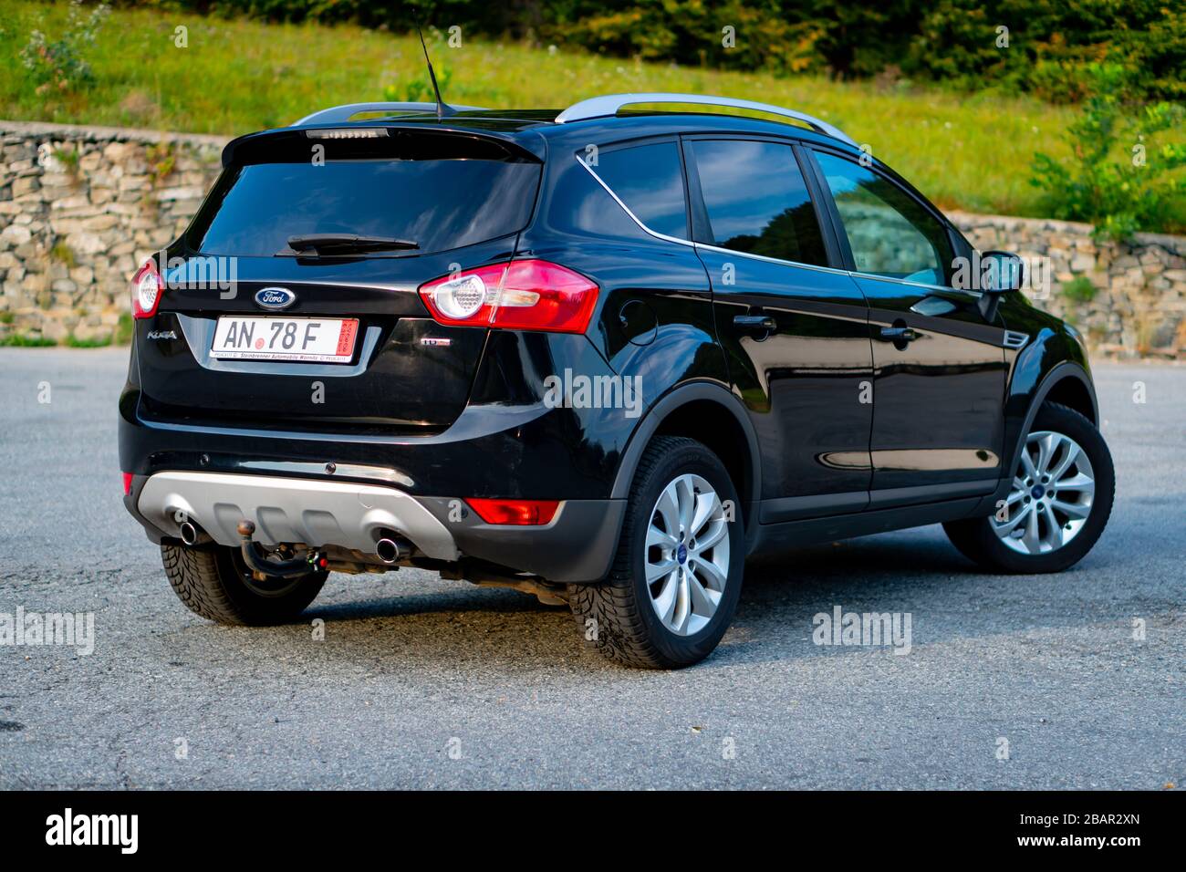 Second generation Ford Kuga SUV, black metallic color, panoramic ceiling, 4x4 traction, automatic transmission, isolated in an empty parking lot, Stock Photo