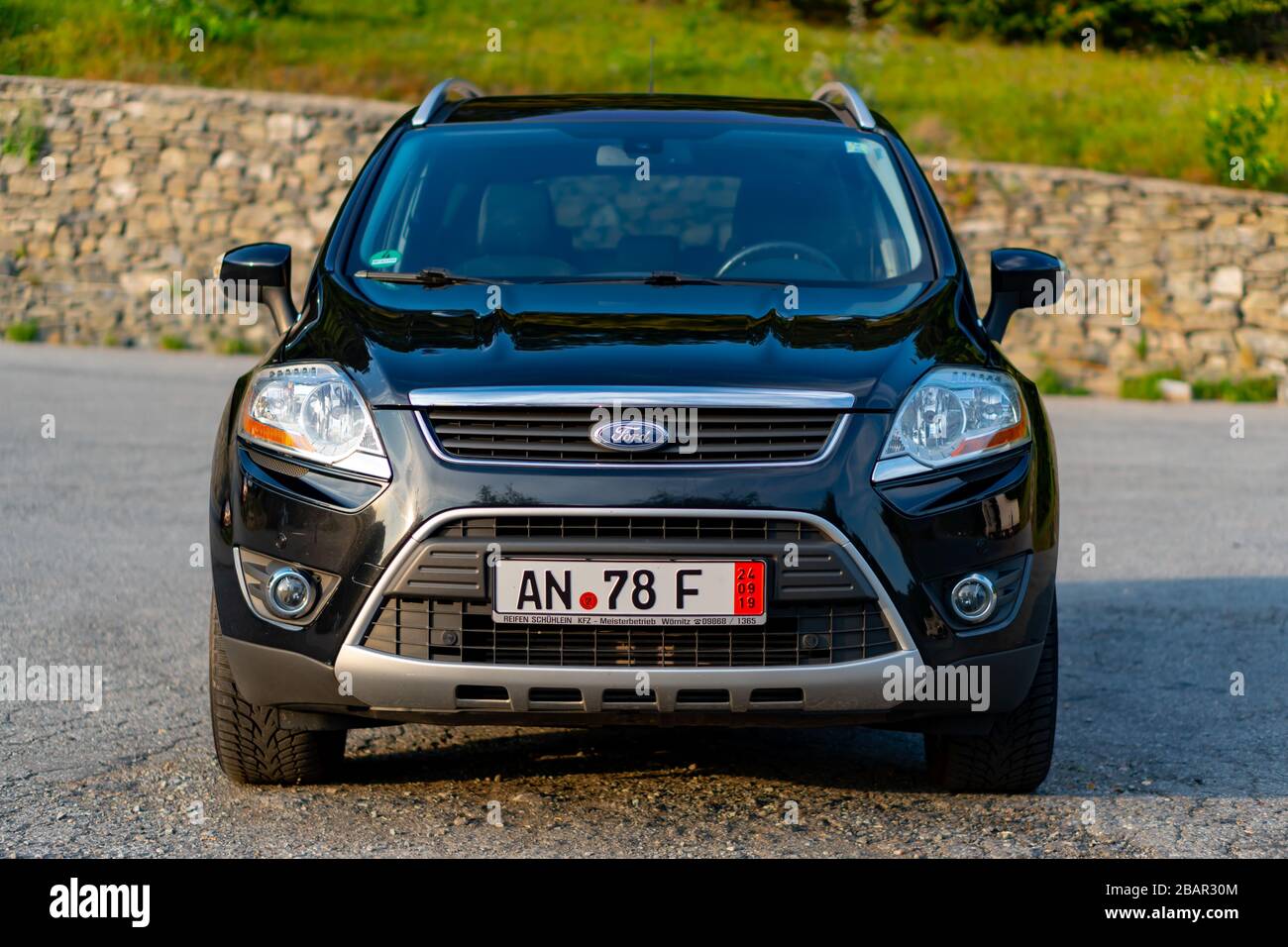 Second generation Ford Kuga SUV, black metallic color, panoramic ceiling, 4x4 traction, automatic transmission, isolated in an empty parking lot, Stock Photo