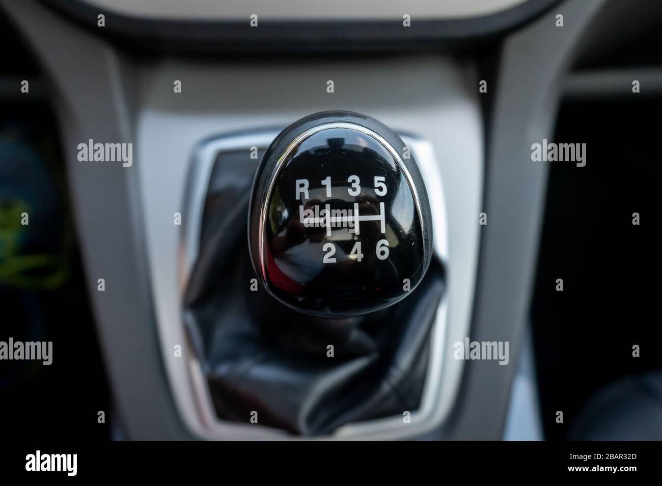 Inside car dashboard view.Detailed close-up photo of manual transmission knob/lever in neutral position.Leather upholstery,6 gear transmission/reverse Stock Photo