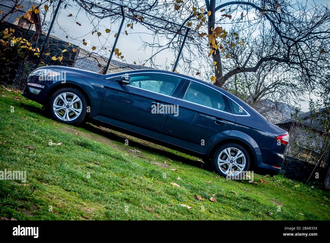 https://c8.alamy.com/comp/2BAR35X/beautiful-sedan-ford-mondeo-mk-4-with-lots-of-extra-equipment-photo-session-in-a-parking-lot-near-a-brown-autumn-forest-grey-colour-with-chrome-2BAR35X.jpg