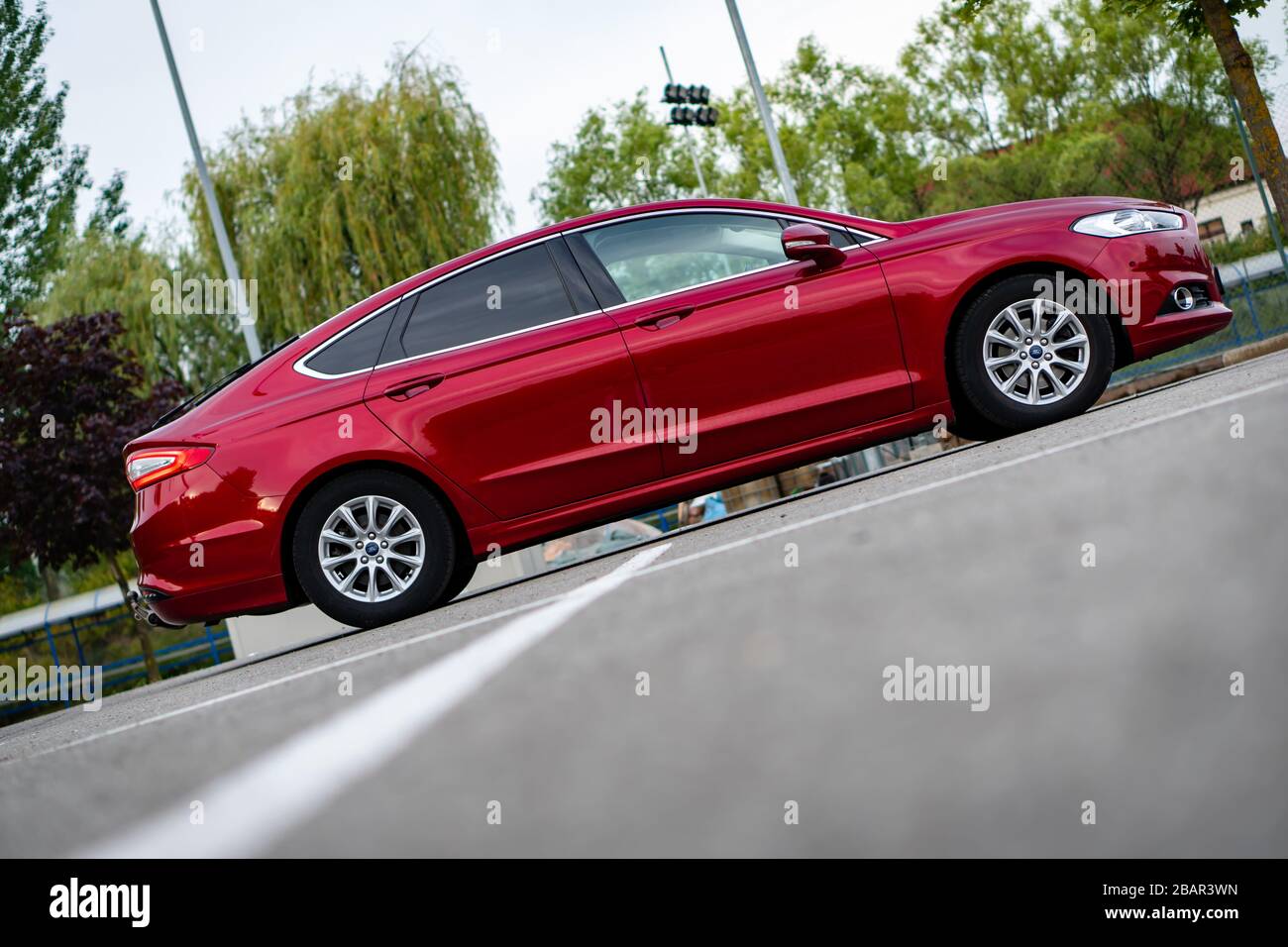 Ford Mondeo MK5 Titanium trim, in Ruby red coloud, sedan, photosession in an empty parking lot. Isolated car, nice photos Stock Photo