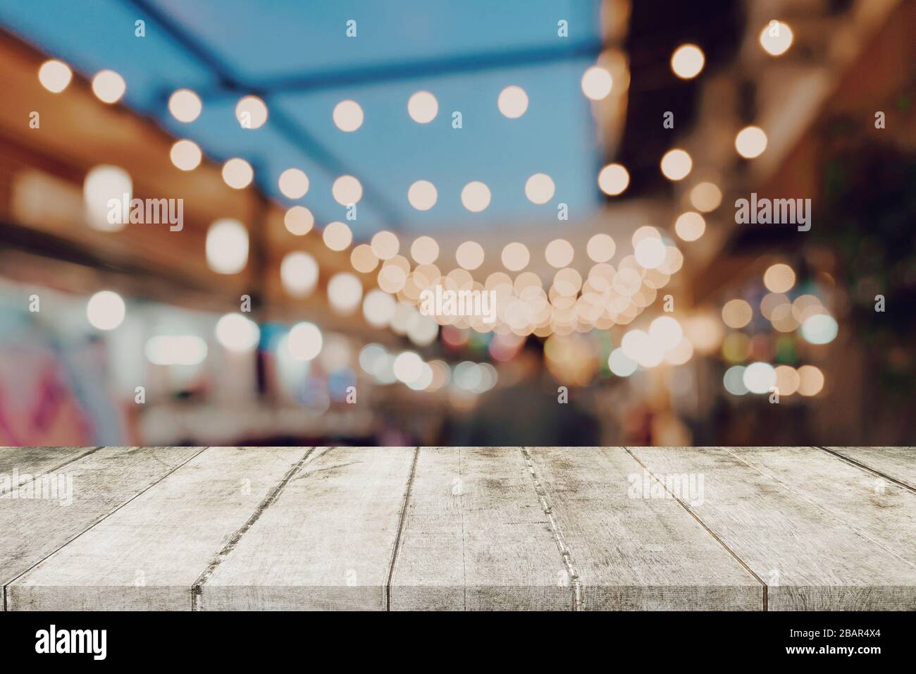Empty wooden table and blurred background at night market festival ...