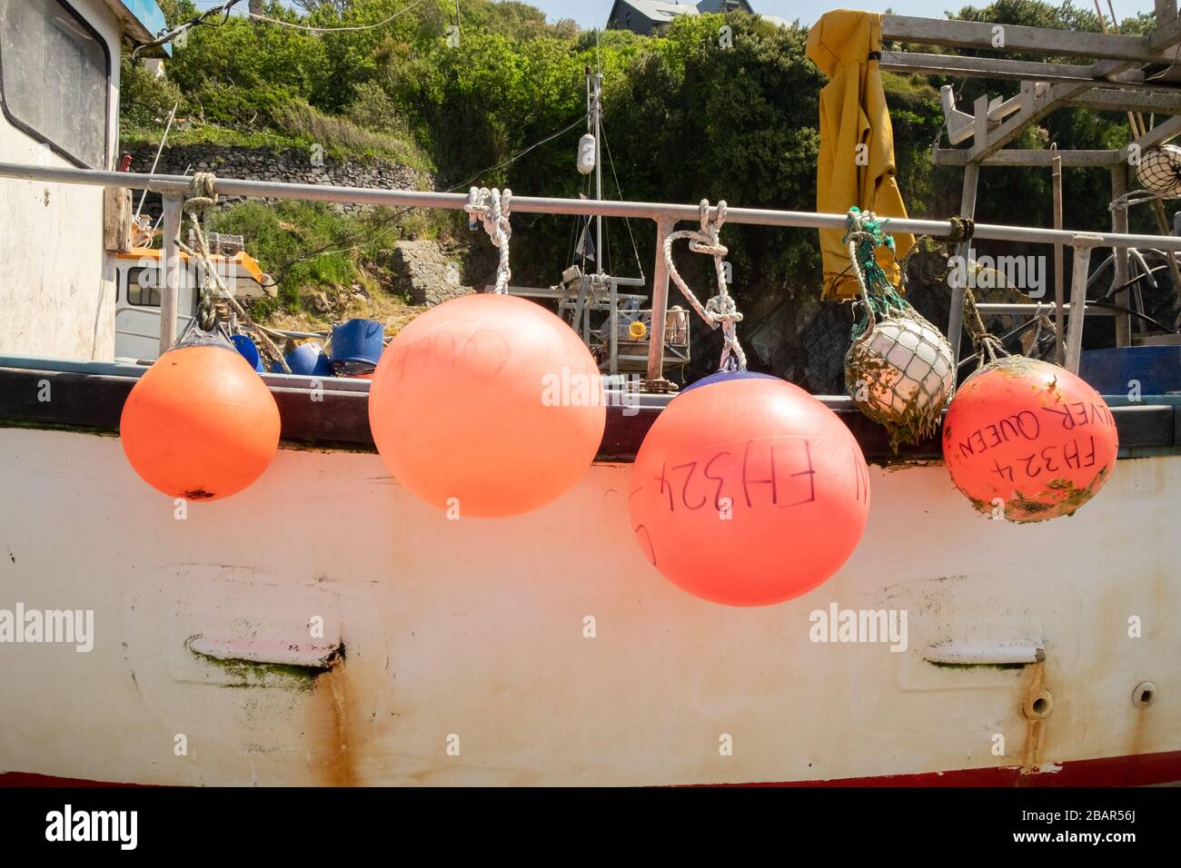 Bright red buoys on traditional fishing boat on the beach of the small fishing village of Cadgwith,Cornwall, England,UK. Stock Photo