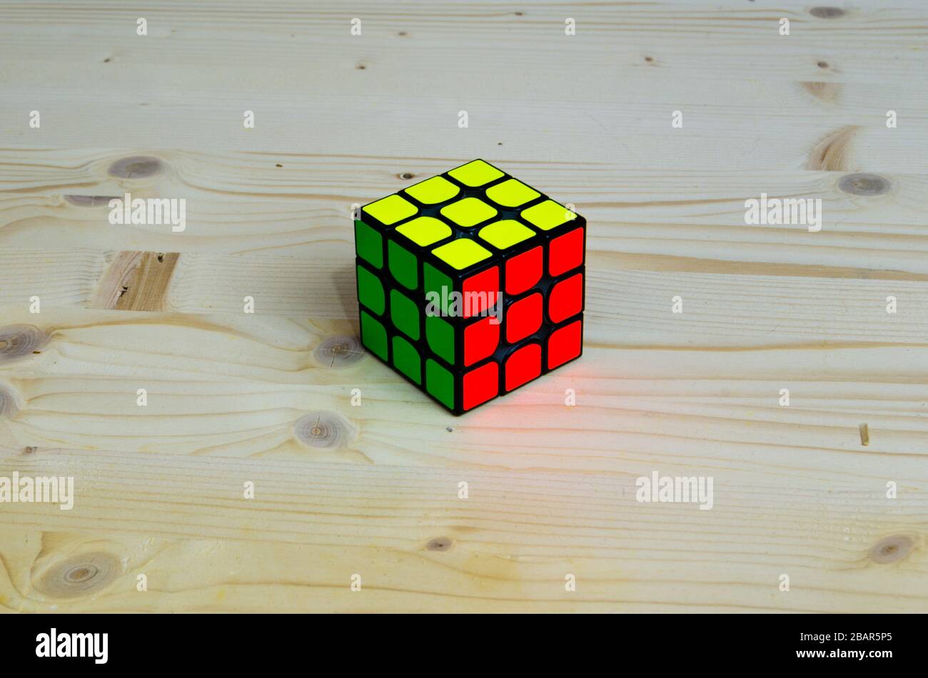 rubik's cube solved on wooden background Stock Photo