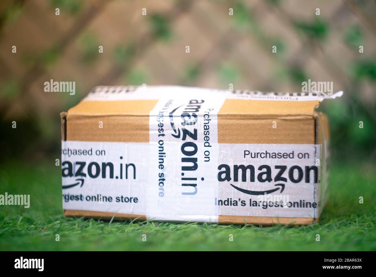 Amazon box with tape on grass outside a house showing the delivery from  this leading e-com player Stock Photo - Alamy
