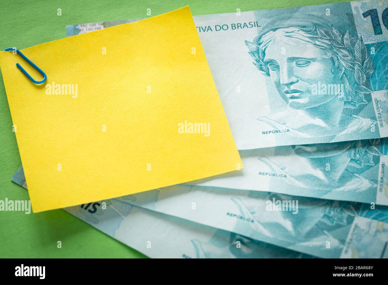 Brazilian money, 100 reais banknotes on green background with blank