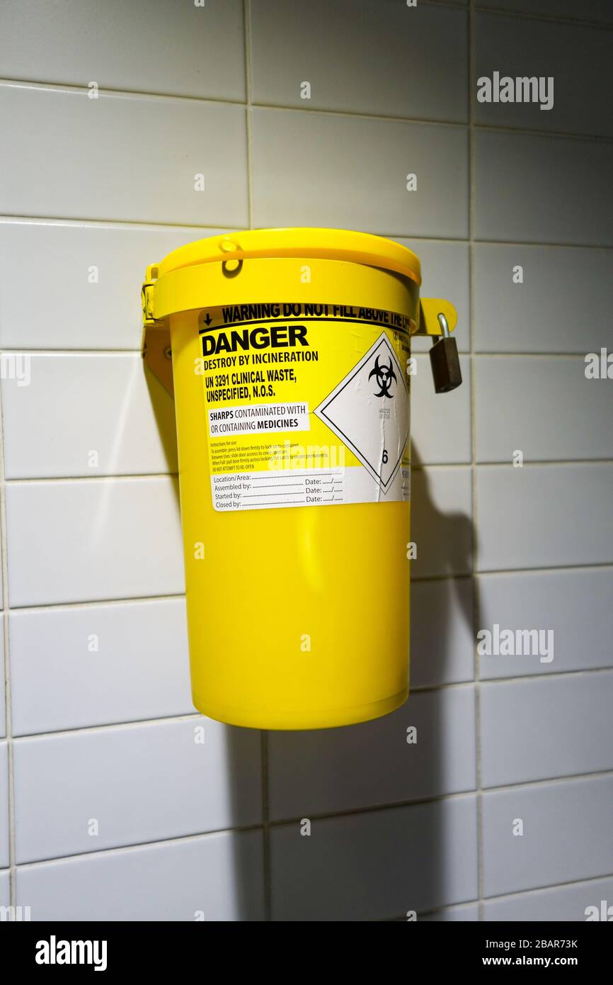 A yellow UN 3291 clinical waste bin on a toilet wall Stock Photo Alamy