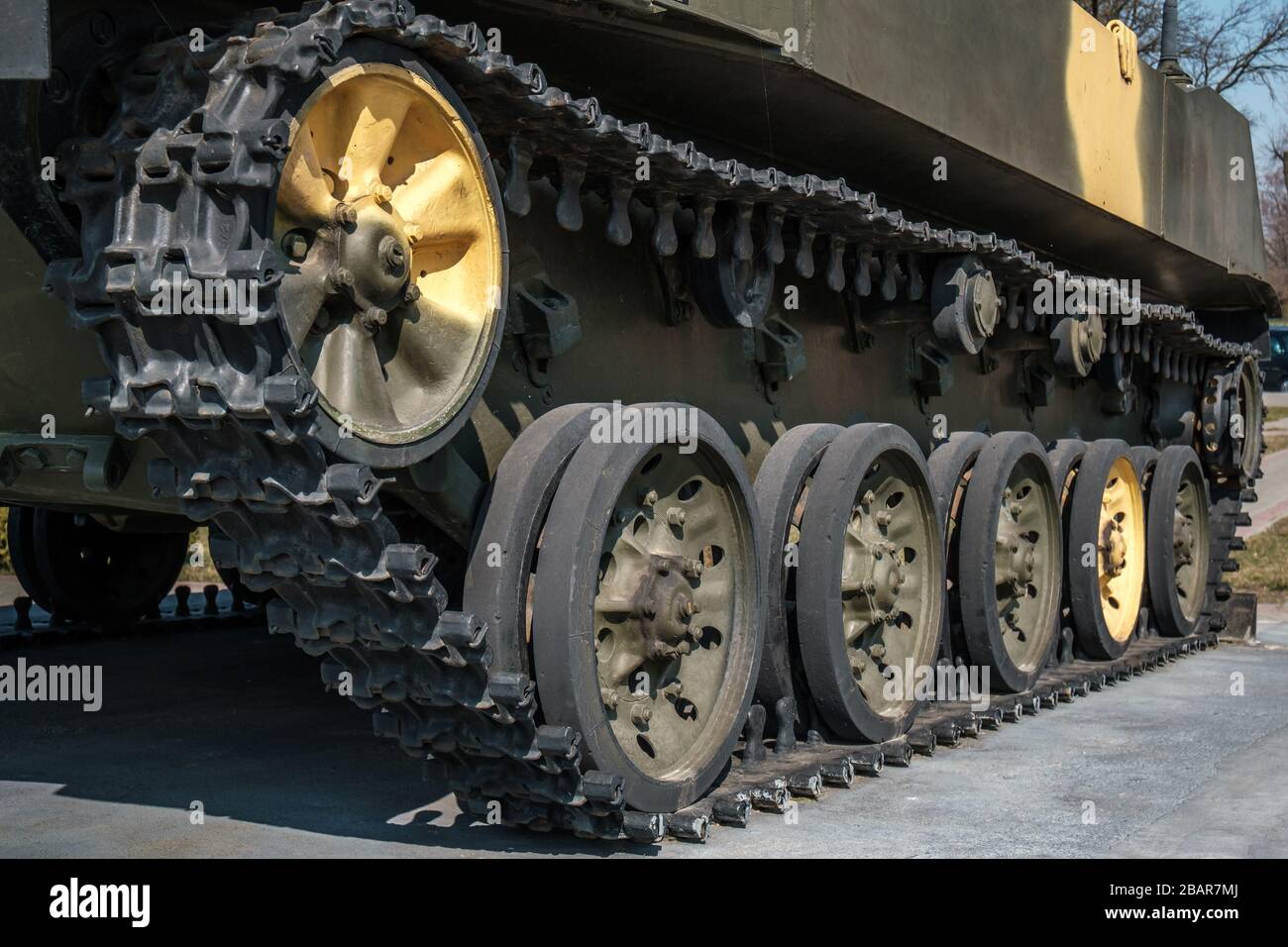 tracks and wheels of tank, armored vehicles on the street in green
