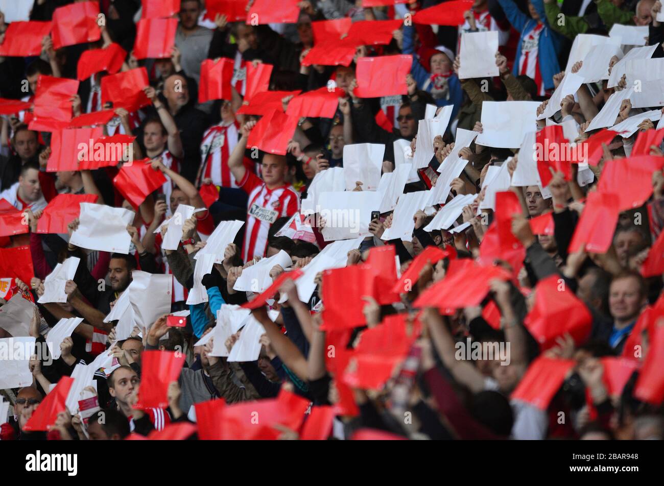 Sunderland fans hold up red and white cards in the stands Stock Photo