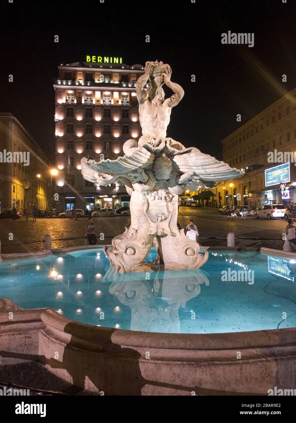 Night closeup of the sculpture Triton with a triton horn on two dolphin heads Fontana del Tritone on the Piazza Barberini in Rome, Italy Stock Photo