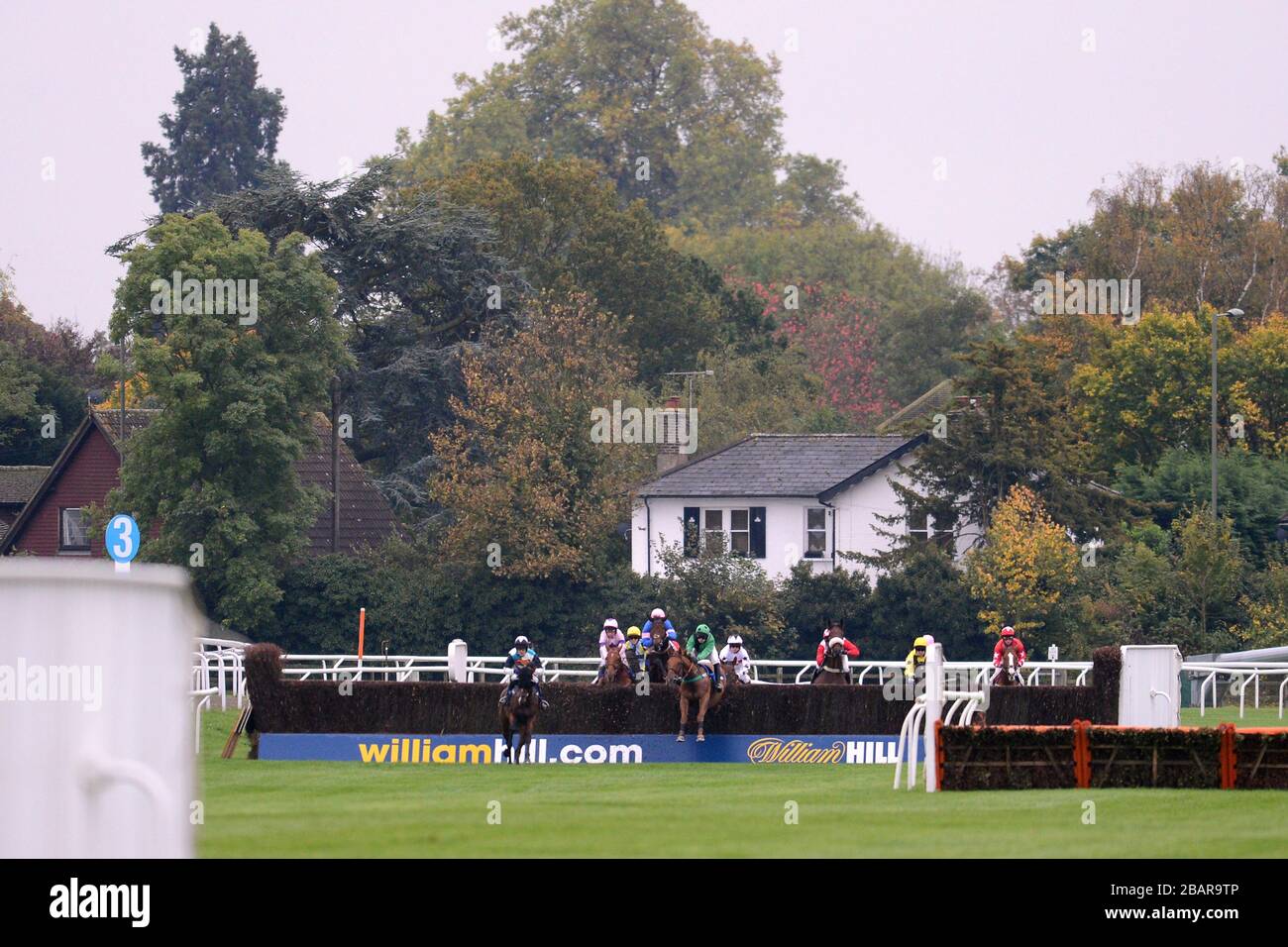 Horses jump the fence sponsored by William Hill during the williamhill.com Beginners' Chase Stock Photo