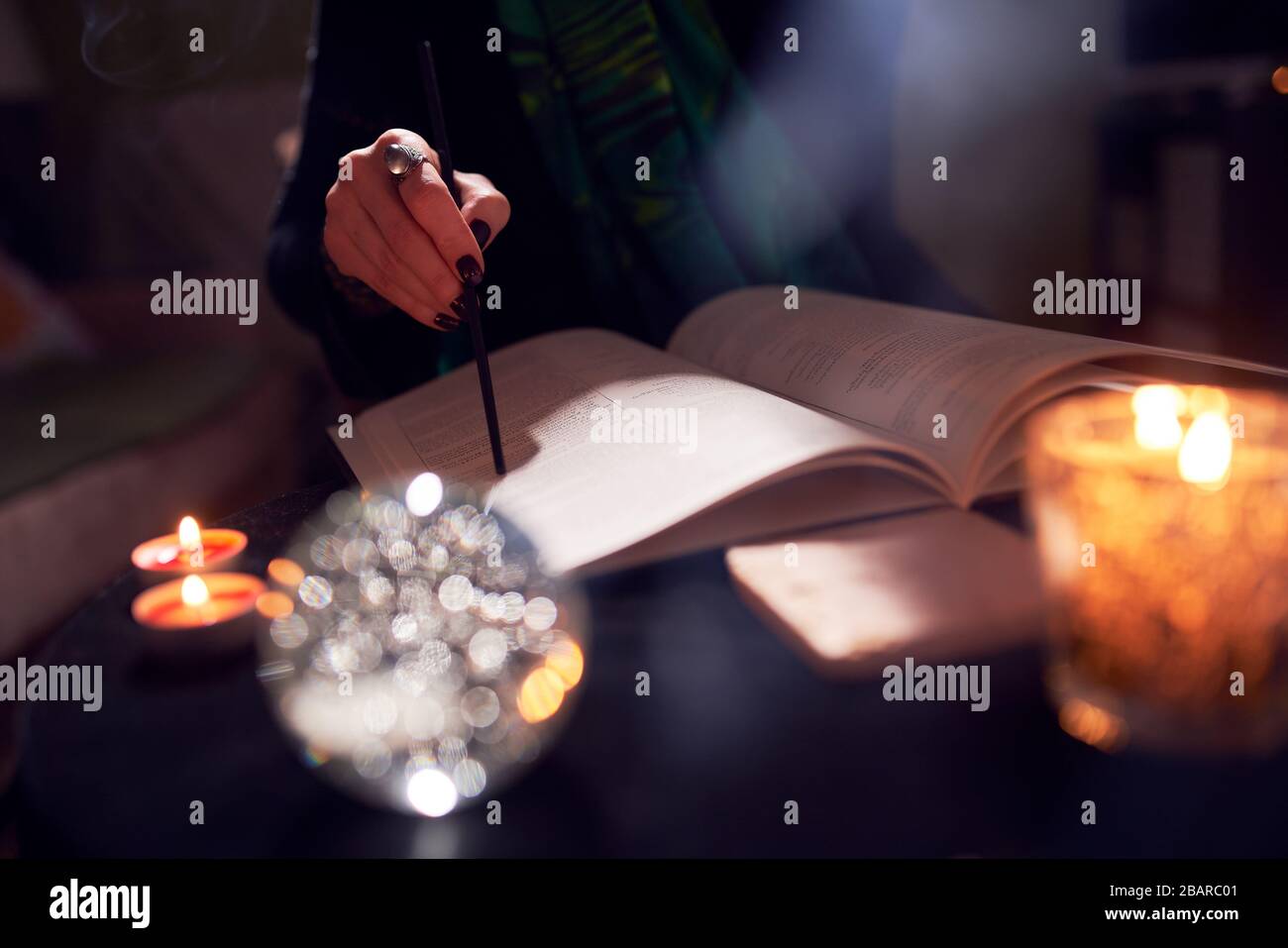 Female fortune-teller's hands, predictions books, predictions ball in room Stock Photo