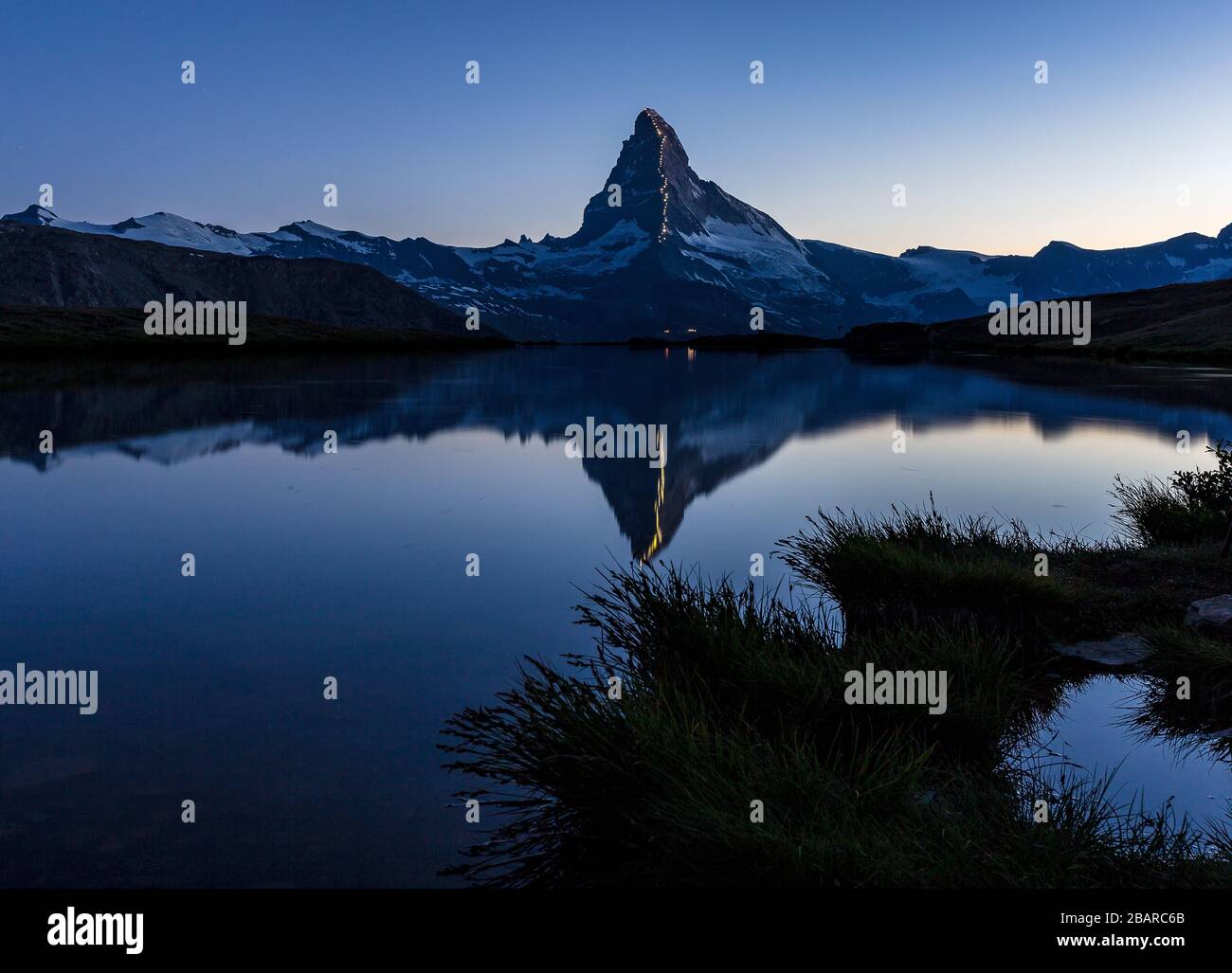 The celebration of 150 years from first ascent of the Matterhorn (Cervino) mountain. Reflection on Lake Stellisee at blue hour. Swiss Alps. Europe. Stock Photo