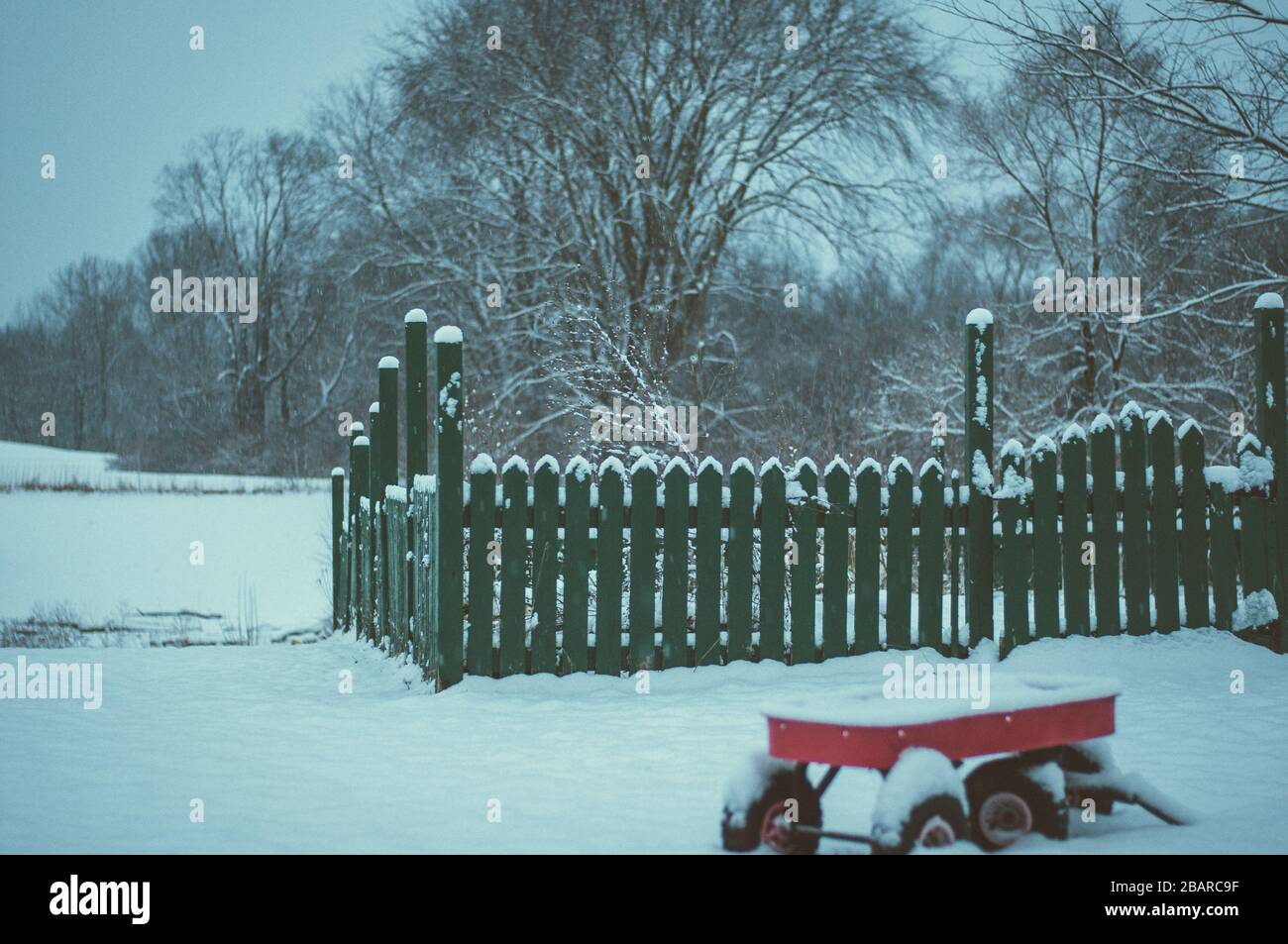 Selective focus shot of a wooden fence covered with white snow during ...