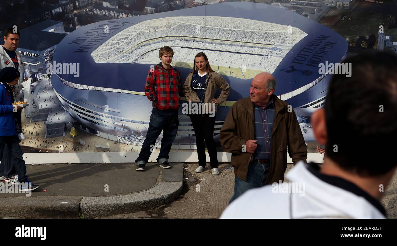 Fans walk past hoardings displaying an artists impression of the clubs' plans for a new stadium to be built next to White Hart Lane Stock Photo