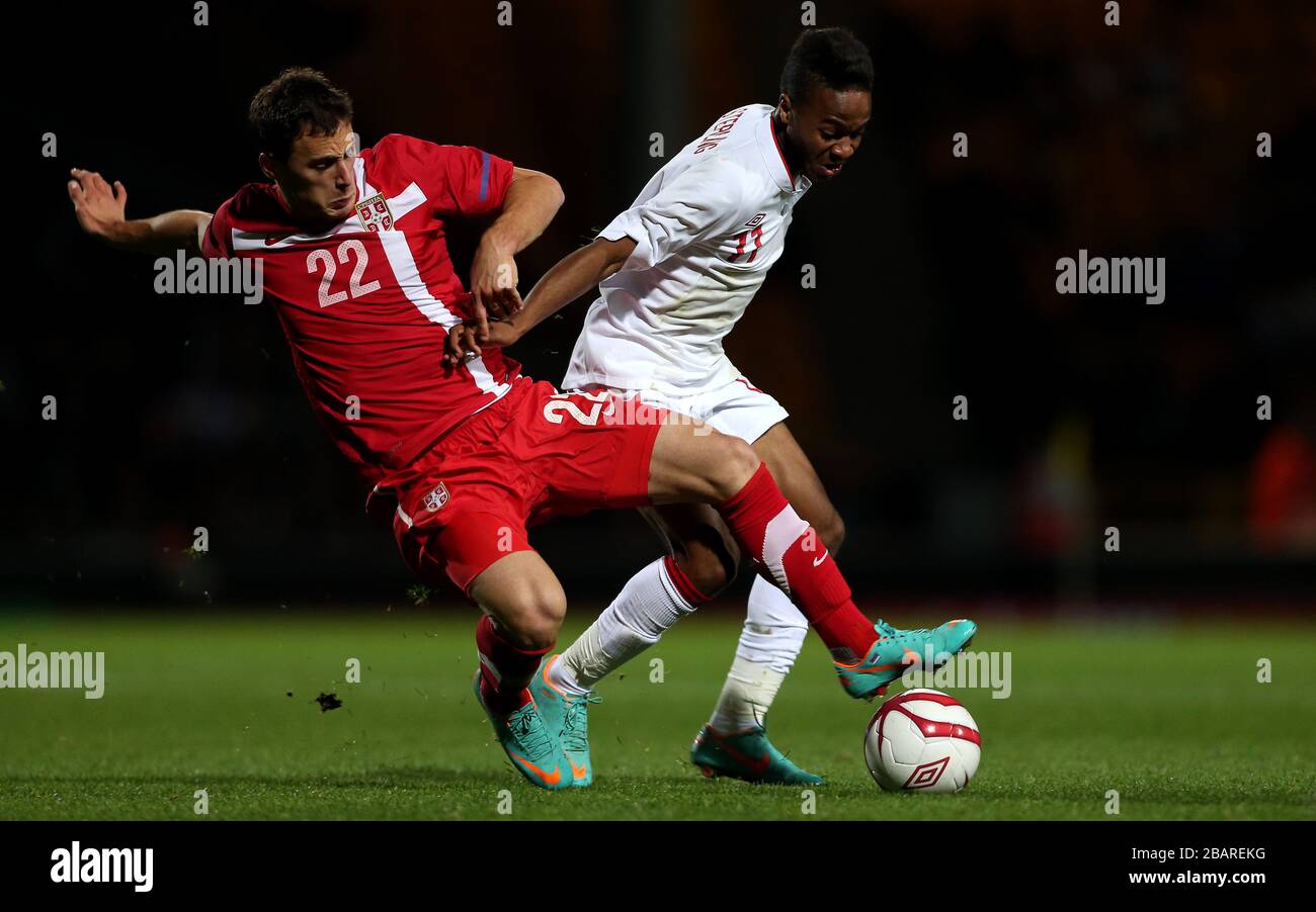 England's Raheem Sterling battles for the ball with Serbia's Filip Malbasic Stock Photo