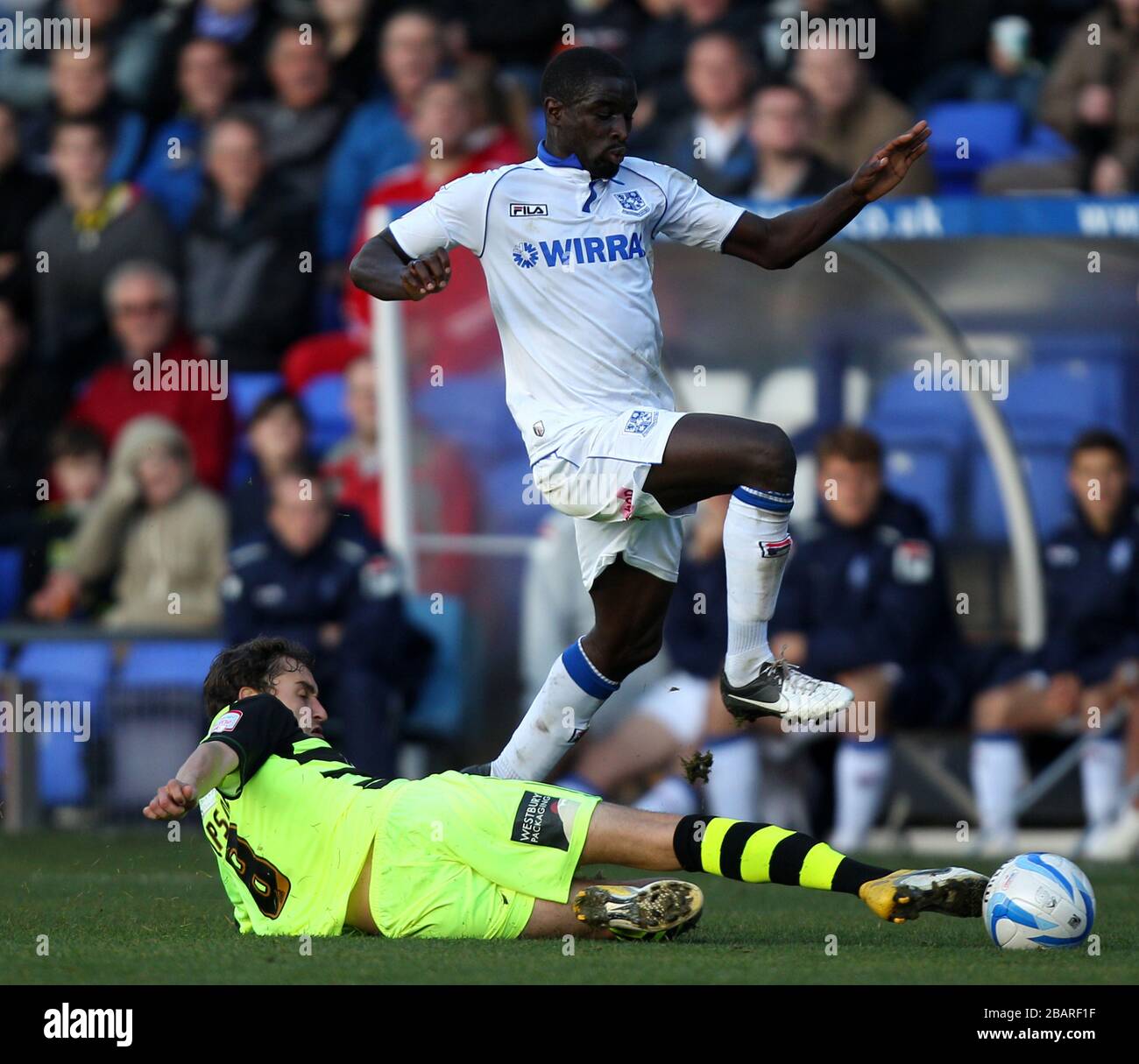 Tranmere Rovers' Zoumana Bakayogo hurdles the challenge from Yeovil Town's Ed Upson Stock Photo