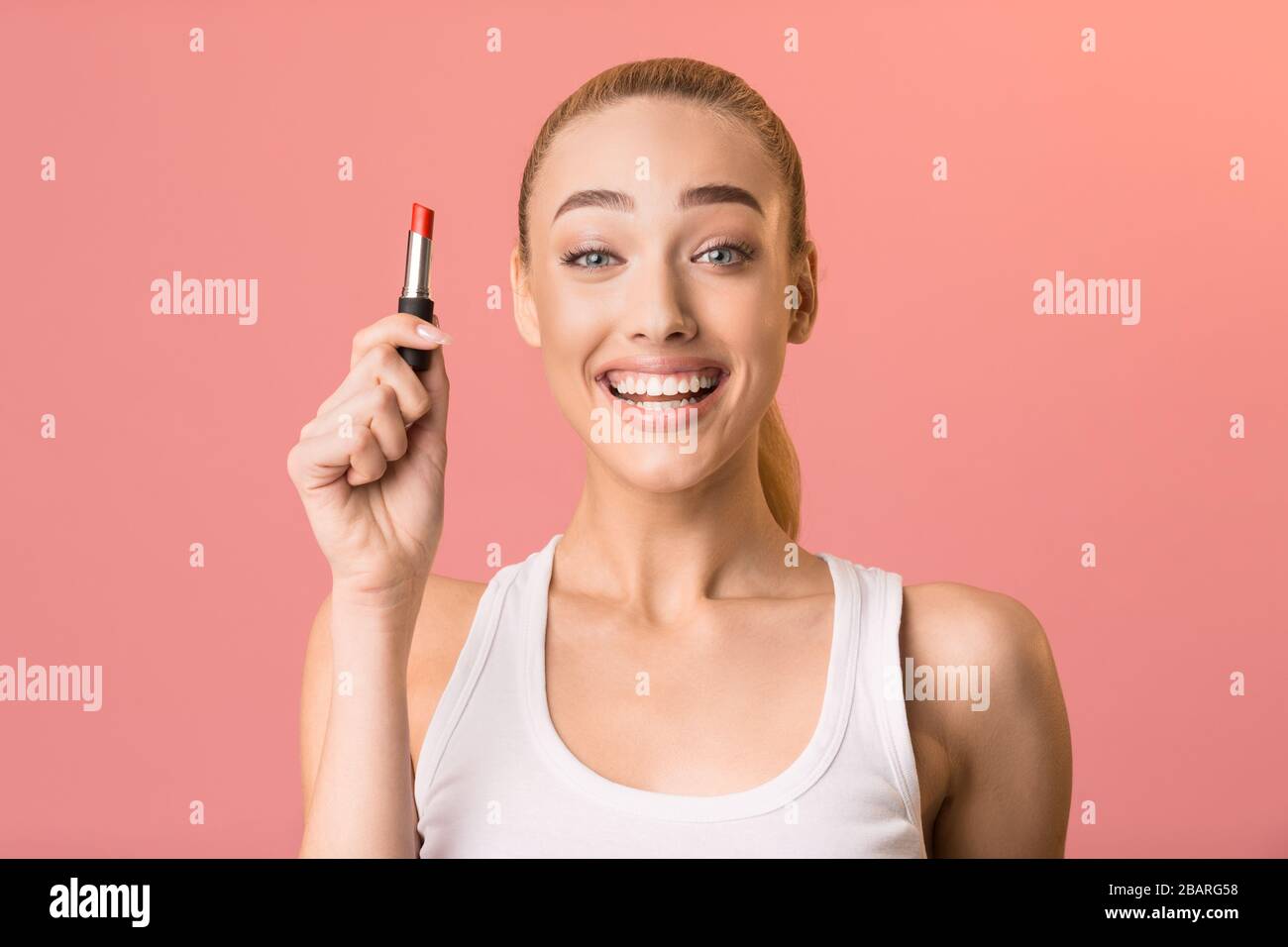 Excited Girl Holding Lipstick Smiling Posing Over Pink Background Stock Photo