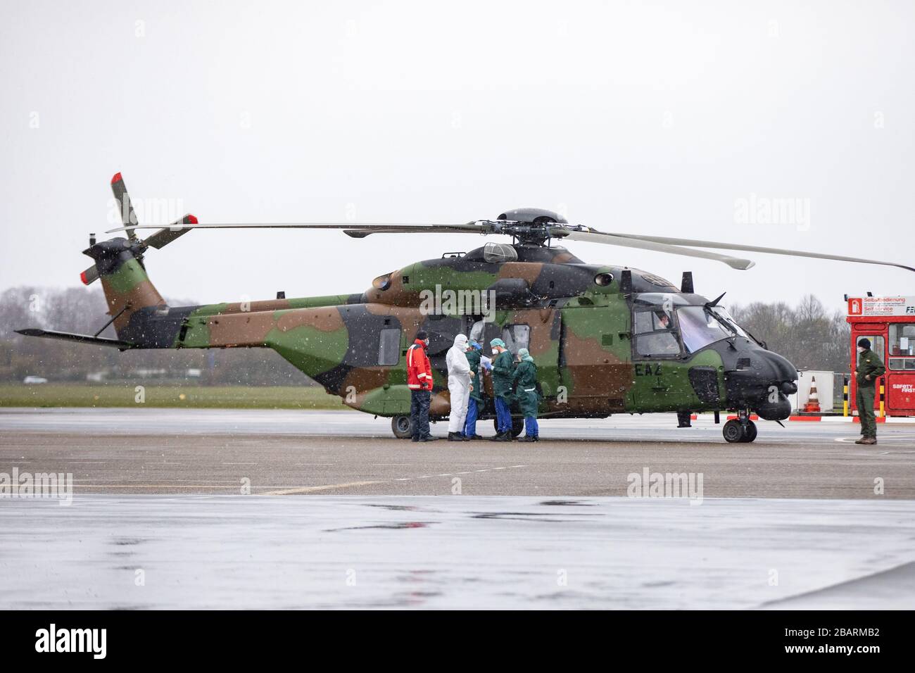 29 March 2020, North Rhine-Westphalia, Mülheim an der Ruhr: Rescue workers in protective clothing get out of a French military helicopter at the airport. Previously, two patients were brought from Metz in France to Mühlheim to be treated at the university hospital in Essen. Photo: Marcel Kusch/dpa Stock Photo